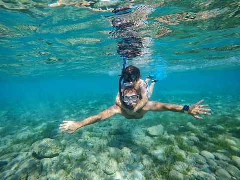 Father and son snorkeling in sea, Zakynthos Island, Greece